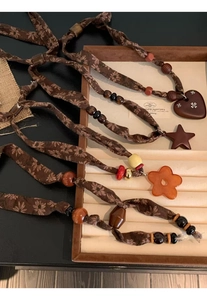 Detailed macro of handmade folk style necklace with wooden beads and star resin pendant