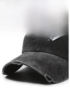 Detailed close-up of charcoal gray washed denim baseball cap with distressed brim and embroidery