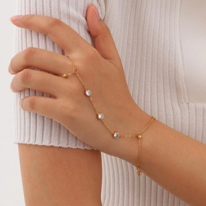 Detail of a gold-plated hand chain with sparkling zircon stones worn by a female model