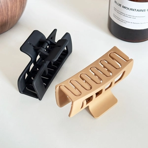 Matte square hair claw clips in black and latte brown on a minimalist white background