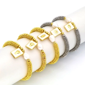 Bohemian stackable bracelet set with gold beads, freshwater pearls and embossed pendants