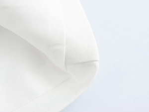 Close-up of white blazer fabric showing premium cotton texture and precise stitching detail