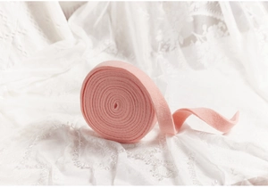 Close-up of soft pink velvet ribbon on lace fabric for Christmas DIY crafting