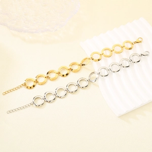 Detail of linked round rings bracelet in gold and silver finish with lobster clasp