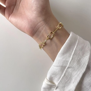 Close-up of a 925 sterling silver chunky link chain bracelet in gold finish on a wrist