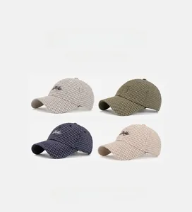 Detail of four plaid baseball caps with Doile embroidery in gray, green, navy, and khaki