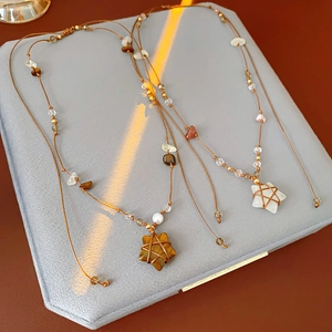 Détail macro de pendentifs étoiles tissés main avec œil de tigre et pierre de lune