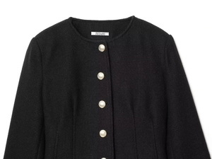 Close-up of black tweed slim-fit blazer showing textured weave and gold buttons