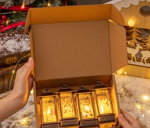 Close-up of four Christmas LED lanterns with festive patterns in a gift box
