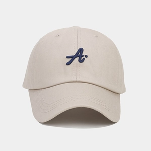Close-up of navy blue embroidered A on beige cotton twill baseball cap with curved brim
