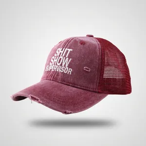 Detail of vintage washed baseball cap featuring white distressed text and red mesh panels