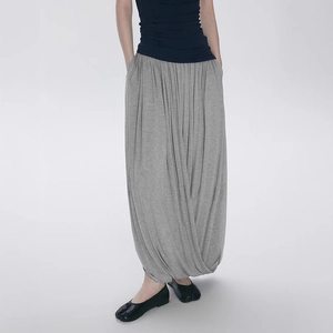 Detailed view of the soft gray knit fabric and loose pleated silhouette of the skirt-pants