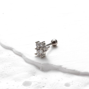 Close-up of silver stainless steel earring with clear zircon cluster on white stone