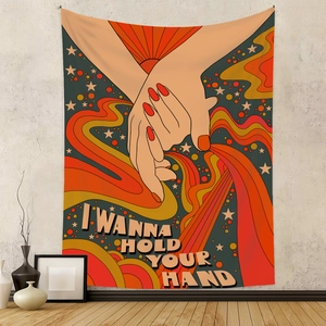 Detail of 70s retro tapestry hanging on a gray wall with I Wanna Hold Your Hand text