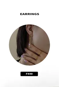 Close-up of gold paperclip drop earrings with purple crushed stone accents