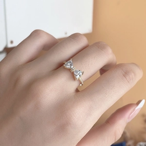 Macro shot of s925 silver bow ring with triangle zircons and pave set diamonds on hand