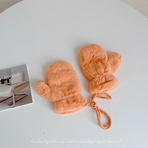 Detail of warm orange plush mittens for children with hanging neck rope and soft texture
