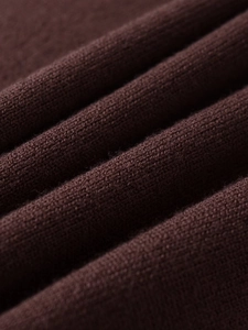 Close-up of brown knit fabric showing soft texture and fine stitching detail on pants set