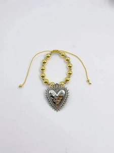 Détail d'un bracelet en perles gothique rétro avec un grand pendentif en cœur argent.