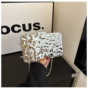 Detail of silver metallic evening bag with hammered texture and chain shoulder strap