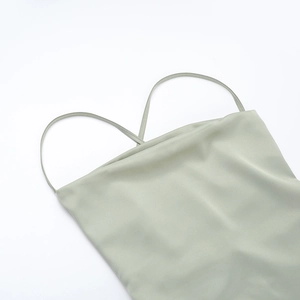 Détail de la robe en satin vert sauge avec de fines bretelles et un col bénitier élégant