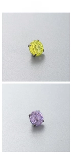 Macro detail of round-cut yellow and purple zircon stones in four-prong titanium settings
