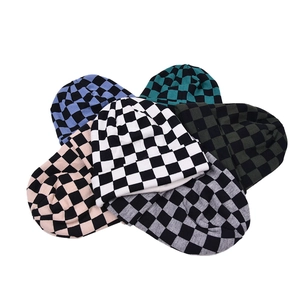 Close-up of six checkered knit beanies in various colors on a plain white background