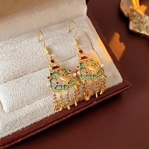 Détail de boucles d'oreilles cœur en or 18K avec pompons en émail rouge et motifs nuages
