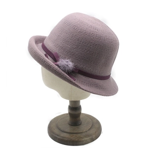 Elegant mauve knitted bucket hat for women with purple ribbon and faux fur pom-pom detail