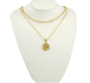 Detail of 18K gold layered necklace with paperclip chain and letter K pendant
