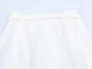 Détail de la taille d'une jupe en dentelle blanche avec texture plume et ceinture