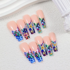 Detailed view of ocean-themed long coffin press-on nails with starfish and anchor charms