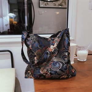 Detail shot of the vintage floral jacquard fabric on the navy blue silk shoulder bag