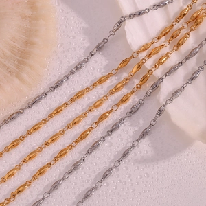 Macro detail of 18K gold and silver plated link chain with olive-shaped metal beads