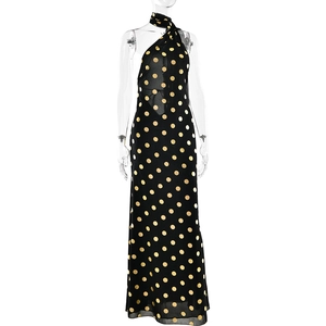 Dettaglio dell'elegante abito lungo nero a pois dorati con raffinato scollo all'americana