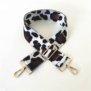 Macro shot of thick leopard print jacquard bag strap with golden metal swivel hooks