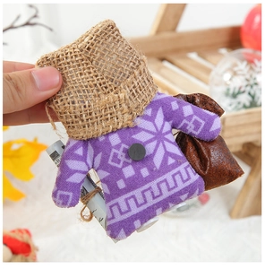 Détail du sac cadeau de Noël en tricot violet avec flocons et garniture en jute