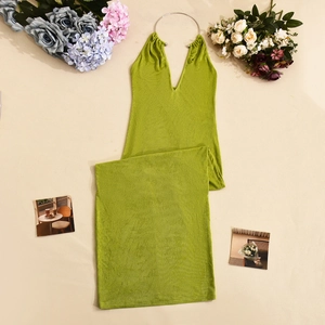 Détail d'une robe longue vert olive avec licou à anneau métallique et texture plissée