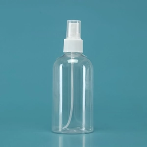 Close-up of a clear plastic perfume spray bottle with white pump and protective cap