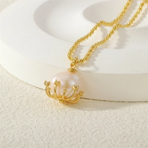 Macro detail of a soft pink pearl pendant necklace with zircon inlay on a white pedestal
