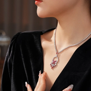 Detailed close-up of a silver floral pendant necklace with pink and clear zircon stones