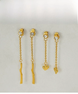 Macro detail of gold tassel earrings set with heart pendants and sparkling rhinestones