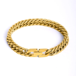 Close-up of golden thick interlocking curb chain bracelet with a secure box clasp