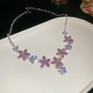 Pink and clear crystal flower necklace set in silver finish on a white ceramic tray