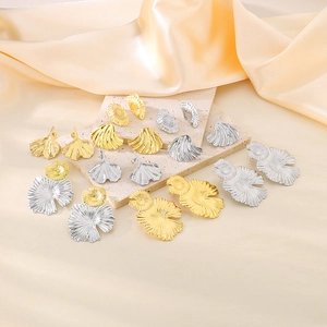 Detail of 18K gold and silver brushed metal earrings with irregular ginkgo leaf textures