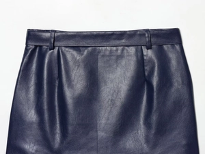 Close-up of deep blue leather mini skirt featuring belt loops and pleated waist details