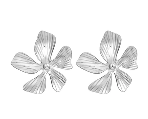 Macro shot of silver five-petal flower earrings with radial textures and 3D relief detailing