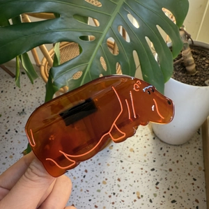 Macro detail of amber hippo claw clip showing translucent acetate texture and orange lines