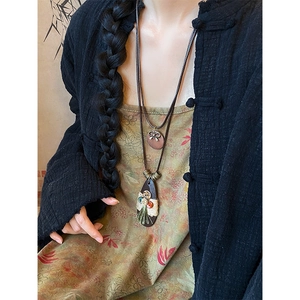 Detailed view of bohemian teardrop necklace with colorful buttons and green tassel