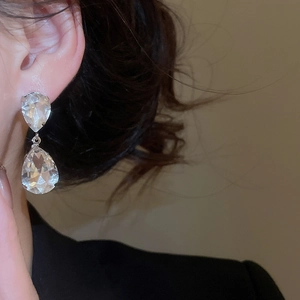 Close-up of a model wearing sparkling water drop tassel earrings with clear zircon stones